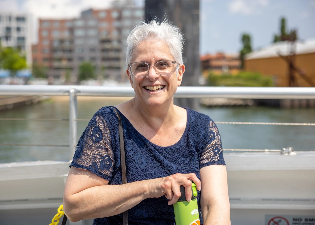 A person with white hair smiling at the camera. There is genuine joy in her expression.